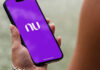 Como investir em criptomoedas pelo Nubank: o guia completo para começar pessoa segurando celular com o aplicativo Nubank aberto mostrando criptomoedas